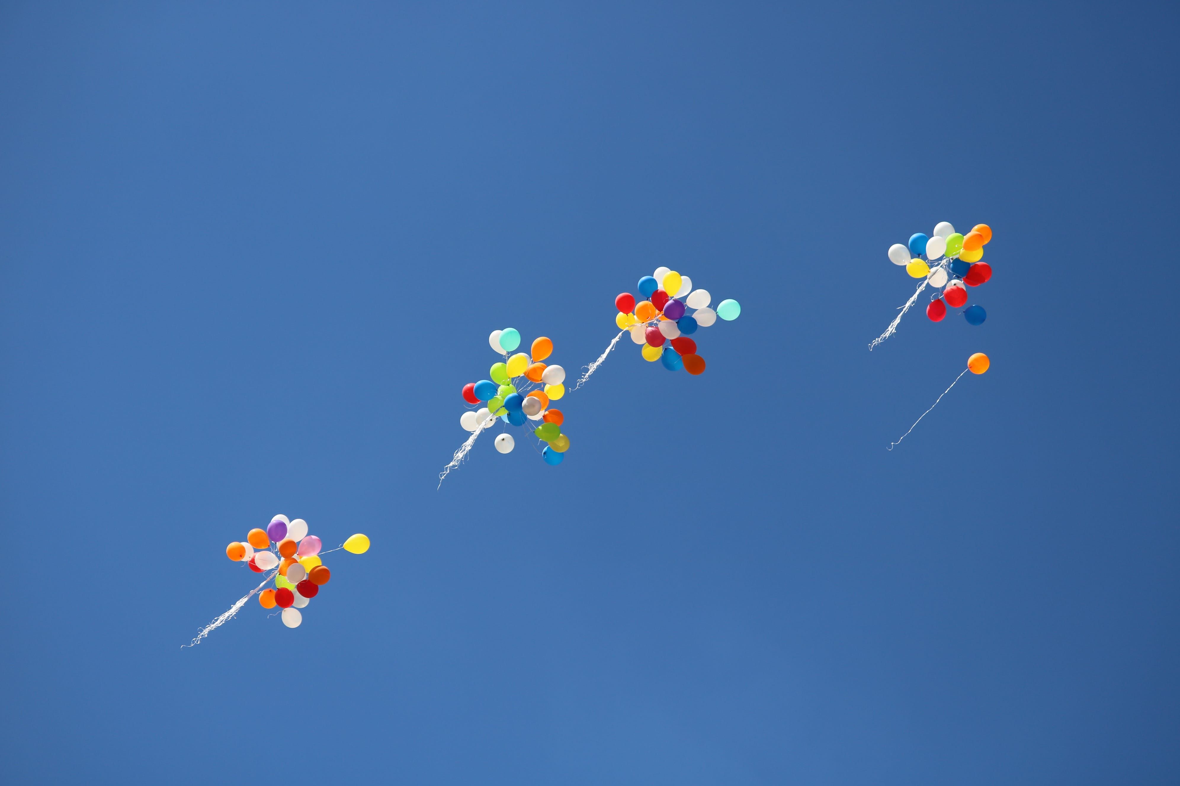 A photo of multiple balloons being released into the sky